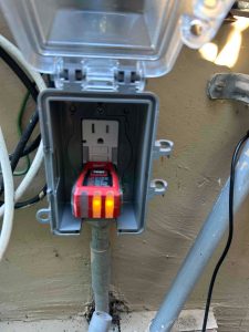 Close-up of a newly installed GFCI outlet with a professional weather-resistant protective cover for outdoor safety.