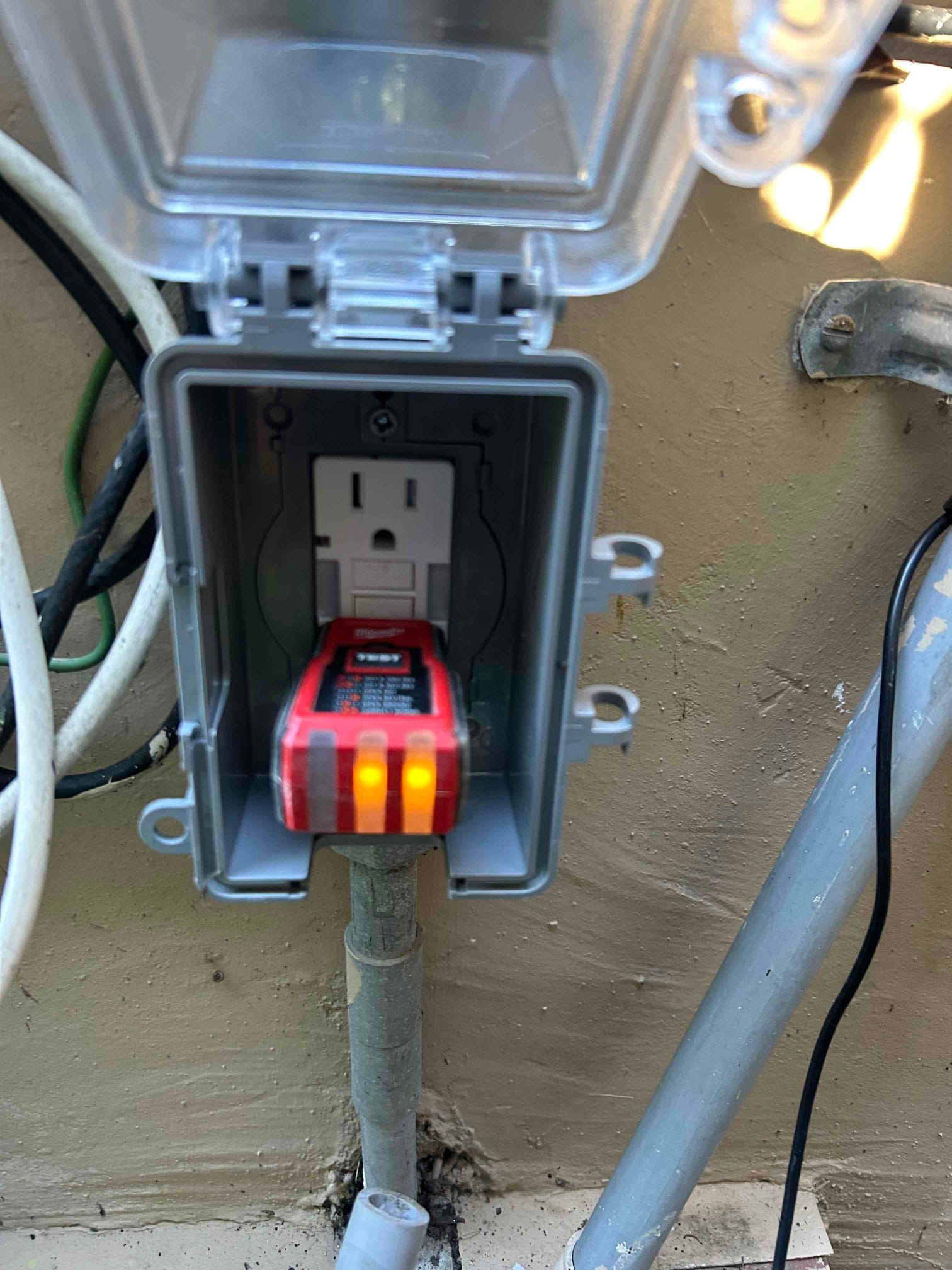 Close-up of a newly installed GFCI outlet with a professional weather-resistant protective cover for outdoor safety.